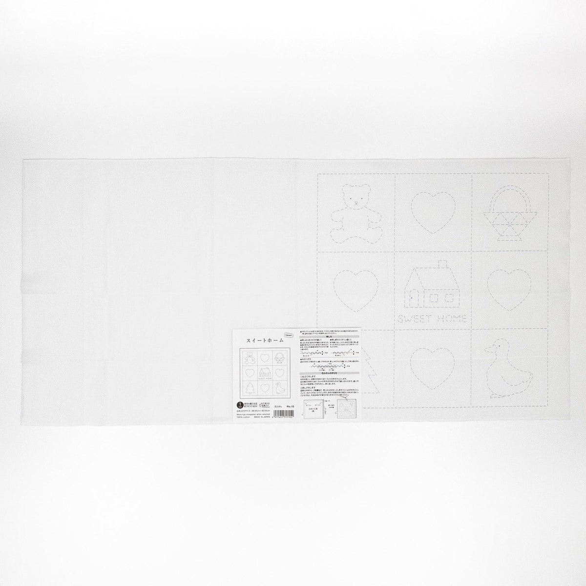 The image is a white sheet of paper with various simple shapes and symbols, including a teddy bear, heart, house, duck, and other geometric designs.