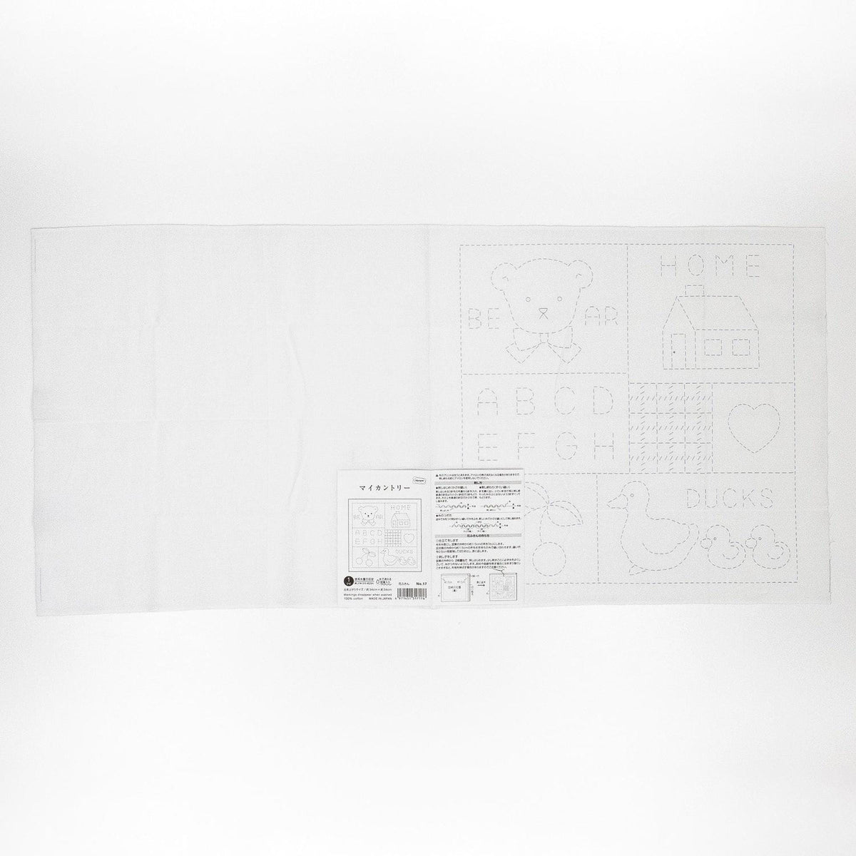 The image is a white sheet of paper with various drawings and text, including a teddy bear, a house, and some other abstract shapes and symbols.