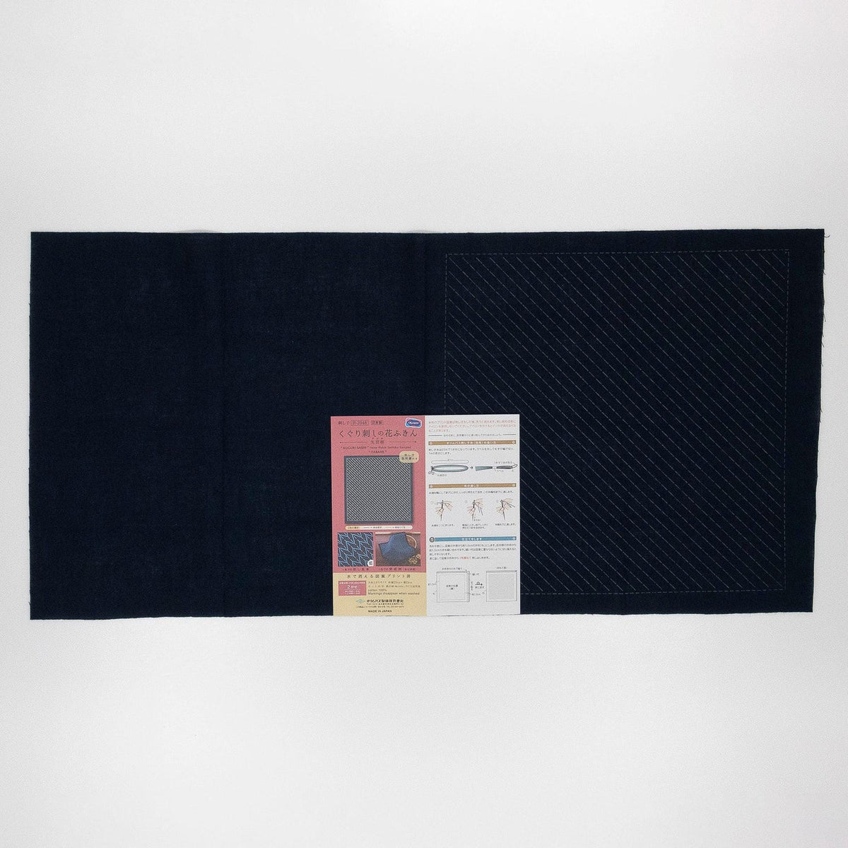 The image is a black fabric with a red and white patterned paper placed on it.