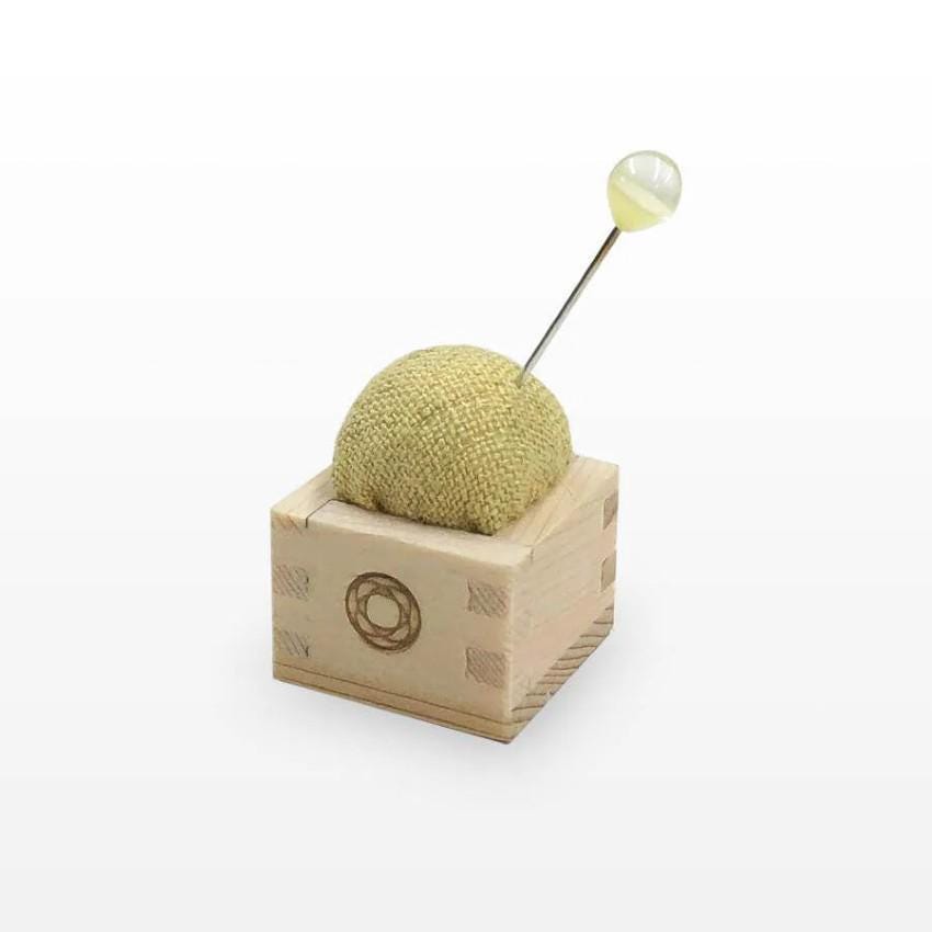 a small wooden object with a pin in it
