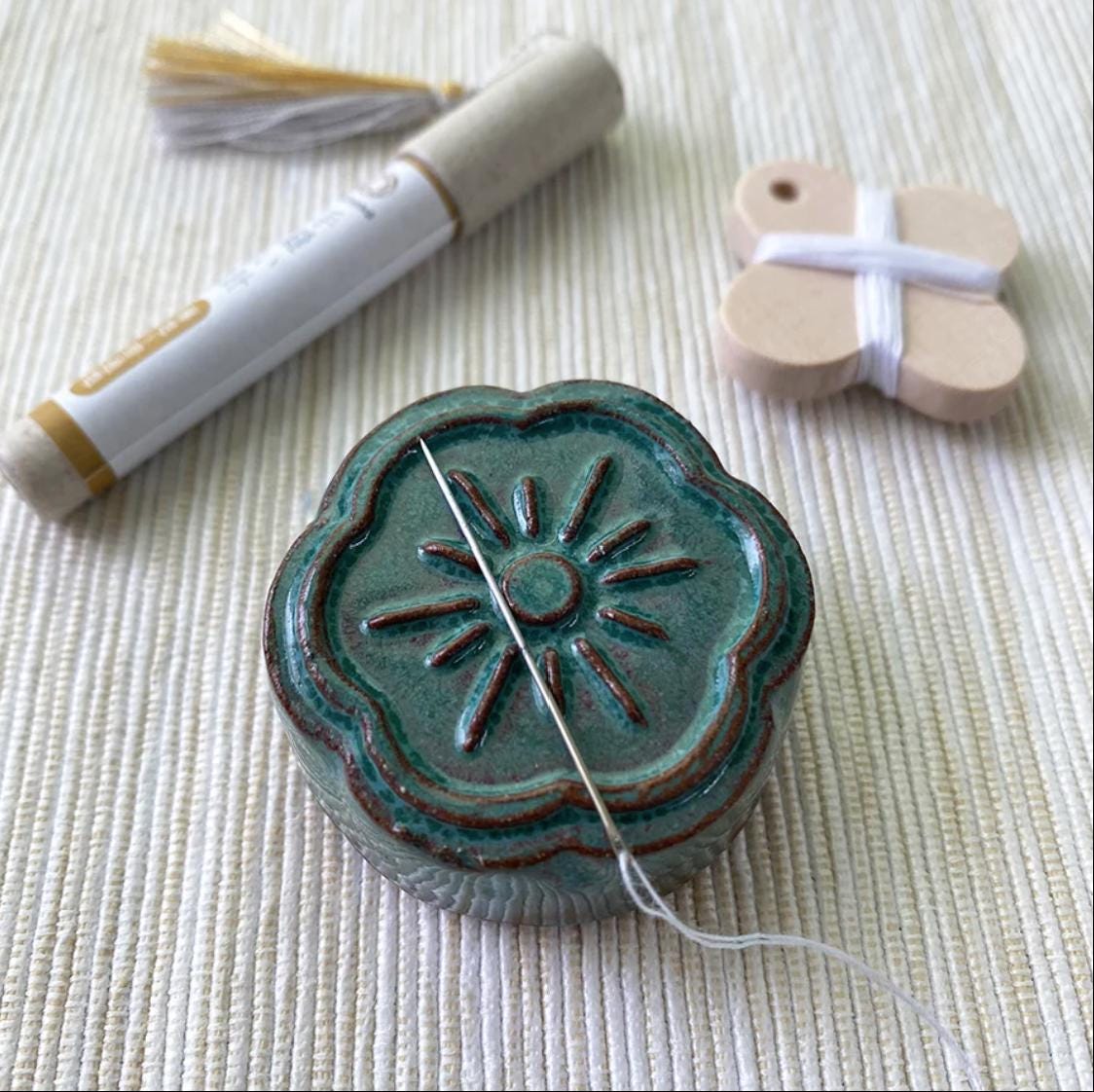 a sewing needle and some craft supplies on a table