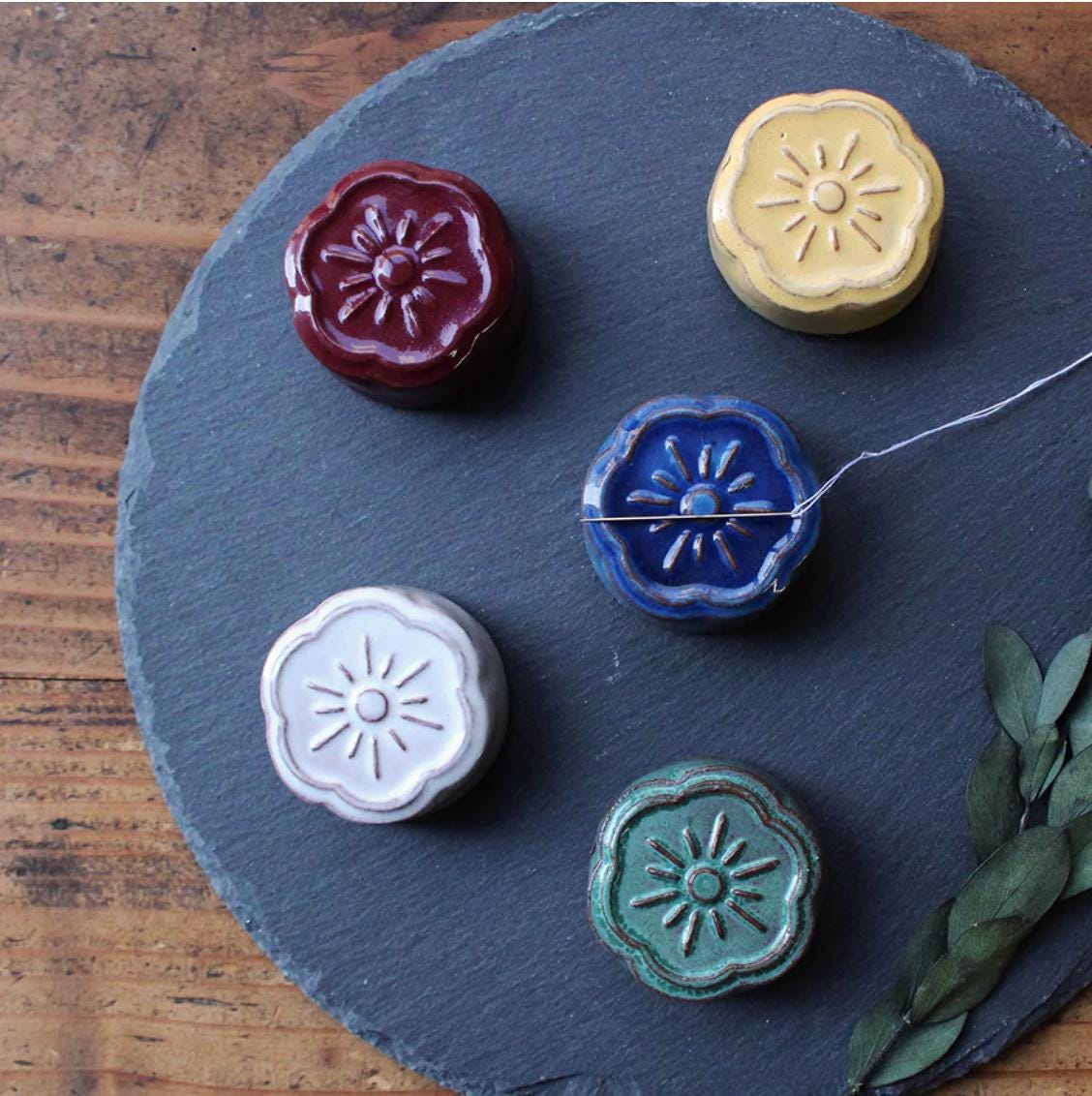four waxed buttons on a slate plate