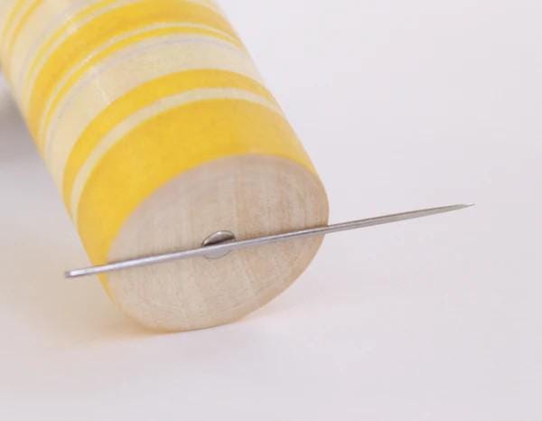 a pair of needles sitting on top of a piece of wood