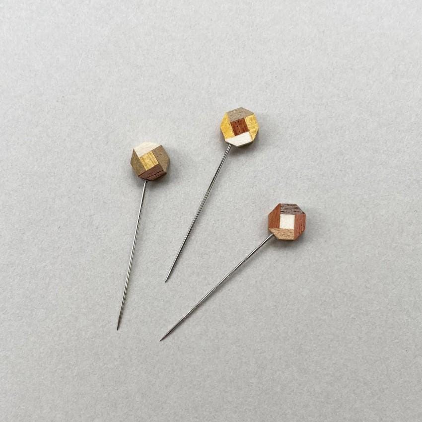 three wooden pins sitting on top of a white surface