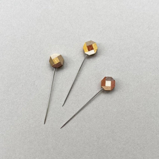 three wooden pins sitting on top of a white surface