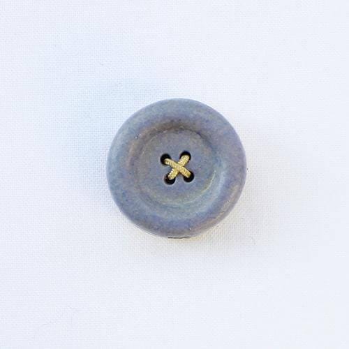 a button with a cross on it sitting on a white surface
