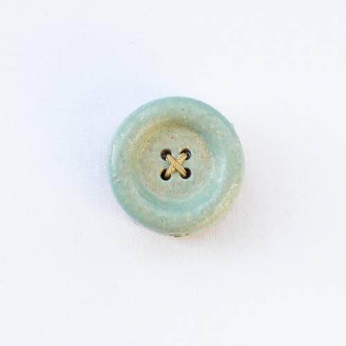 a button with a flower on it sitting on a white surface