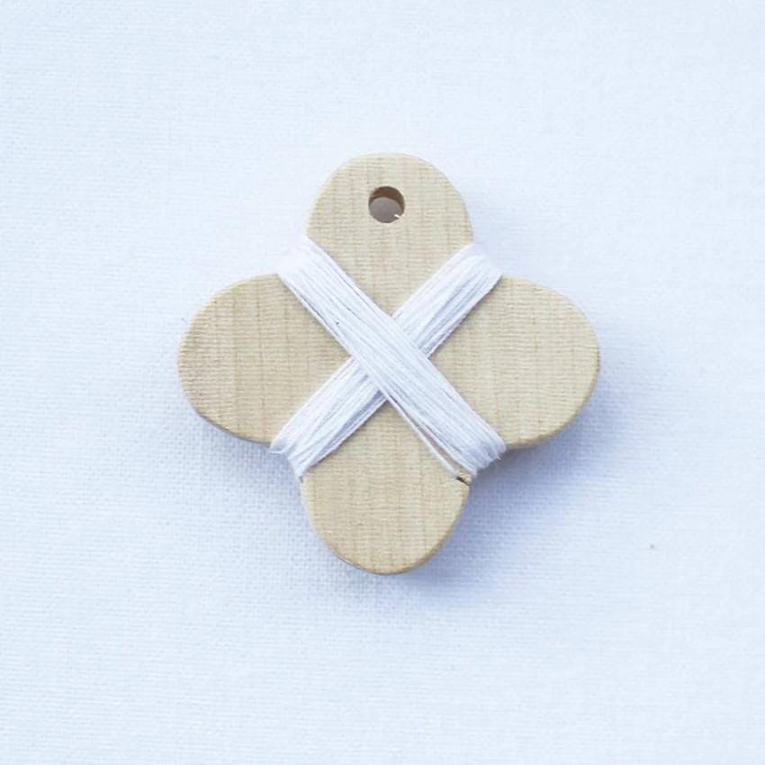 a wooden button with a cross on it