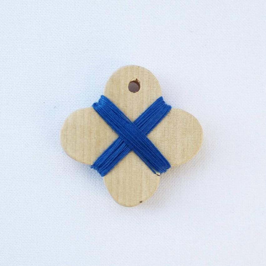 a wooden brooch with a blue ribbon on it