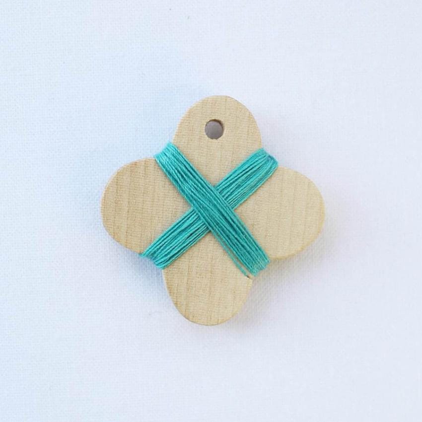 a wooden button with a blue ribbon on it