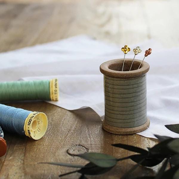 a spool of thread next to a spool of thread