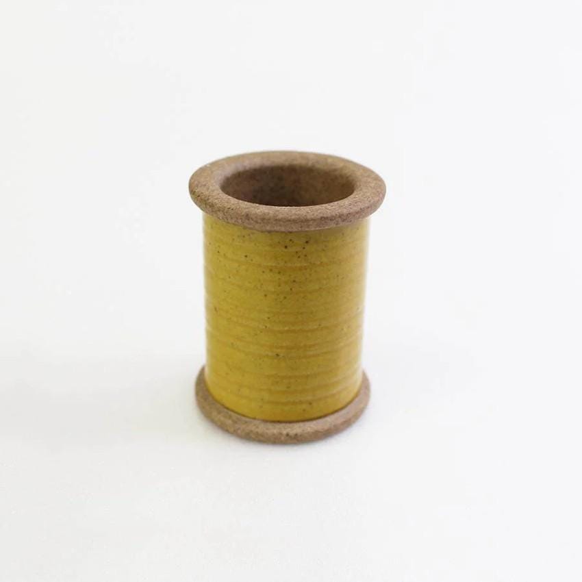 a spool of thread on a white surface