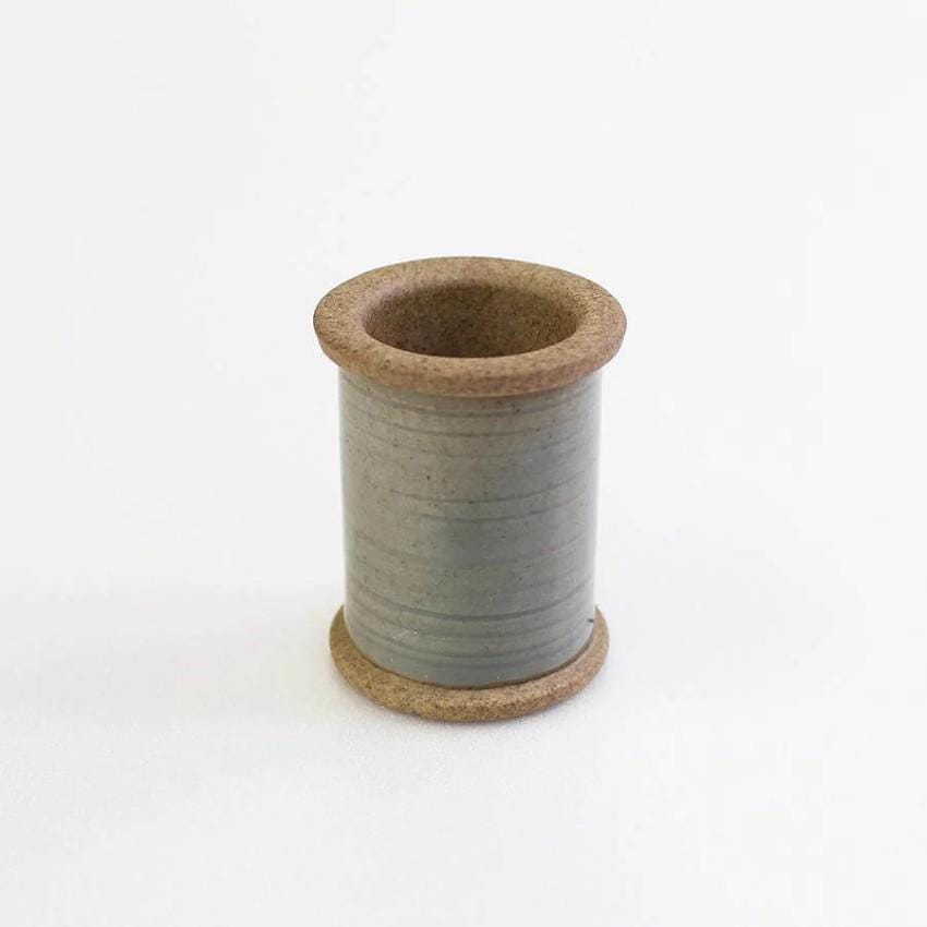 a spool of thread sitting on top of a white surface