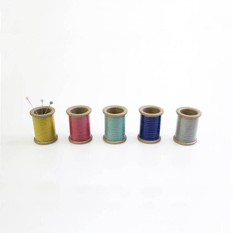 four spools of thread sitting next to each other