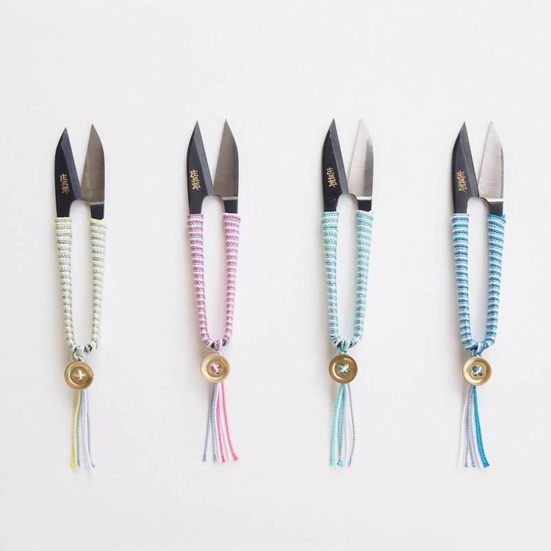 a group of four knives with different colored handles