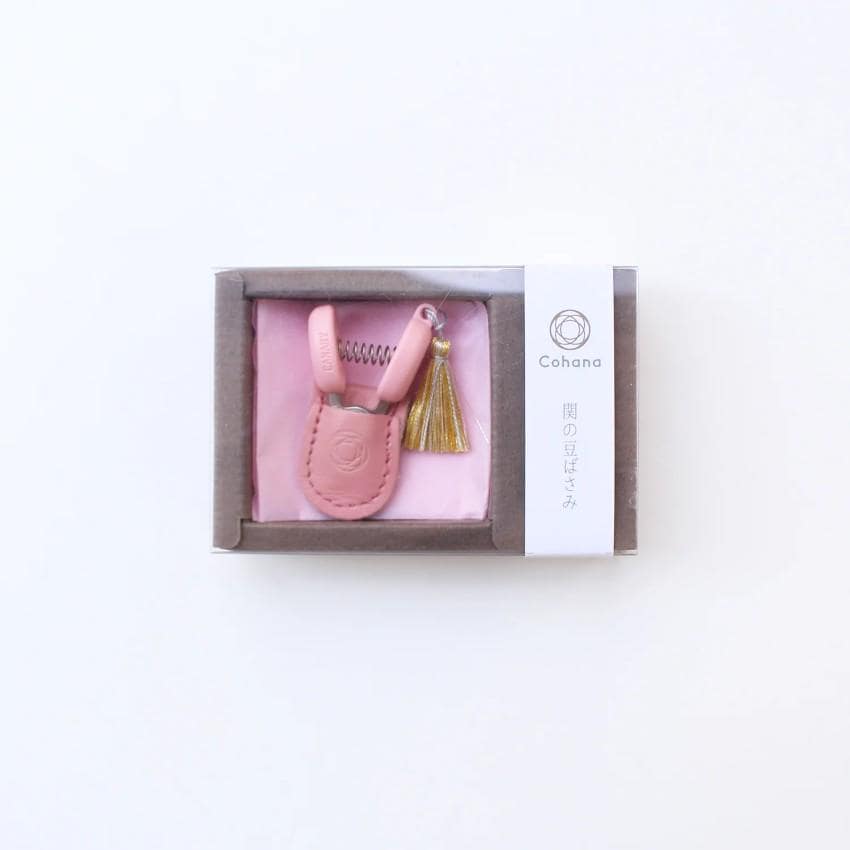 a pink case with a comb and a tassel in it