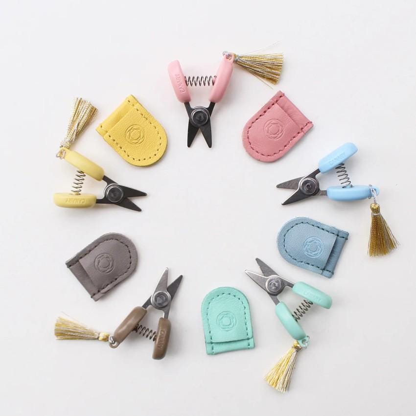 a collection of miniature scissors and combs arranged in a circle