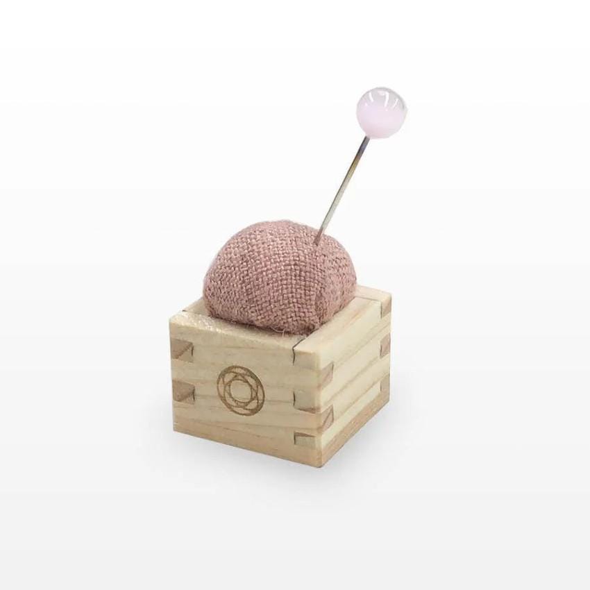 a wooden box with a ball of yarn on top of it