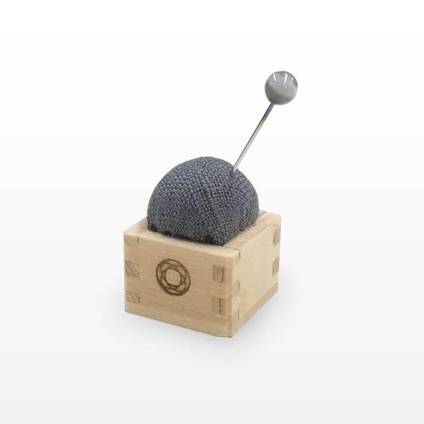a ball of yarn sitting on top of a wooden block