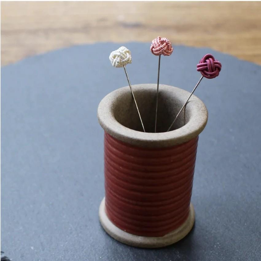 a cup that has some pins in it