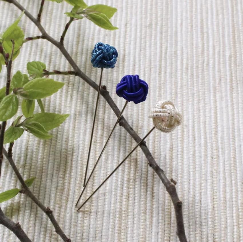 three blue and white flowers sitting on top of a table