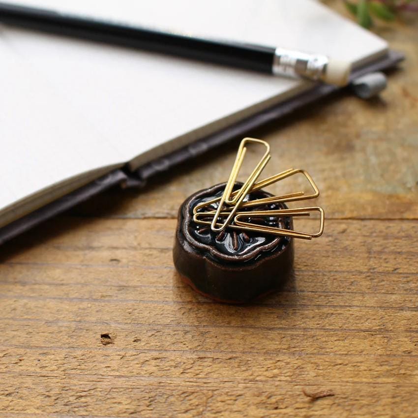 a wooden table topped with a clipboard and a pen