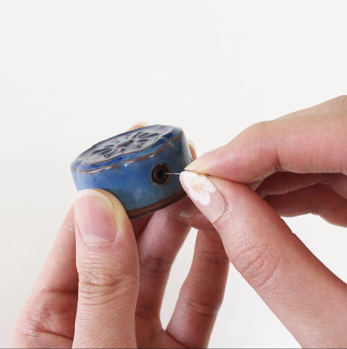 a person holding a small blue object in their hands