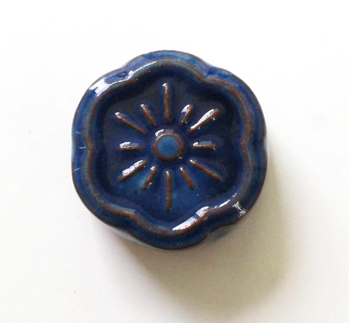 a small blue ceramic object on a white surface