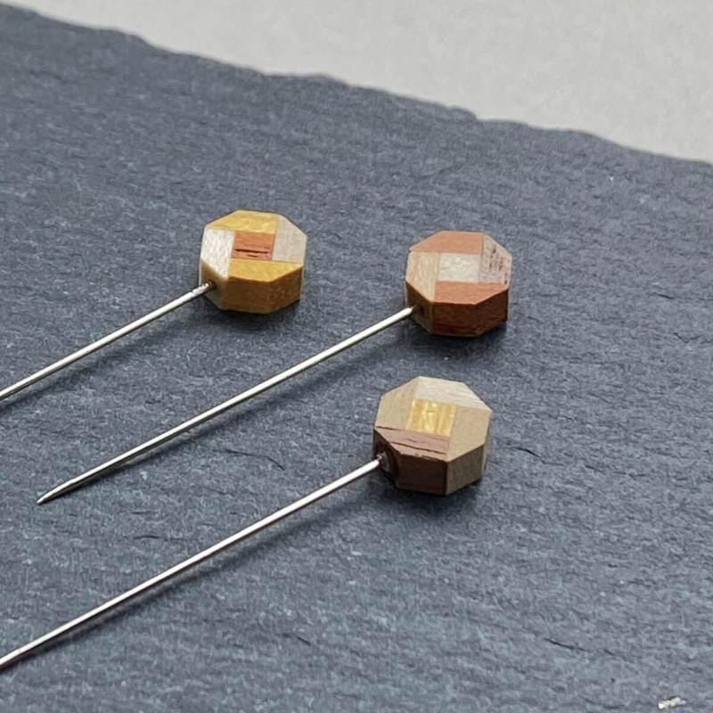a group of three wooden magnets sitting on top of a table