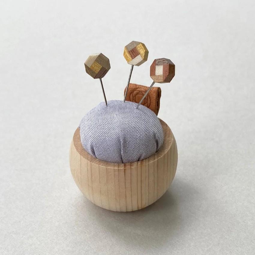 a small wooden object with three wooden pins sticking out of it