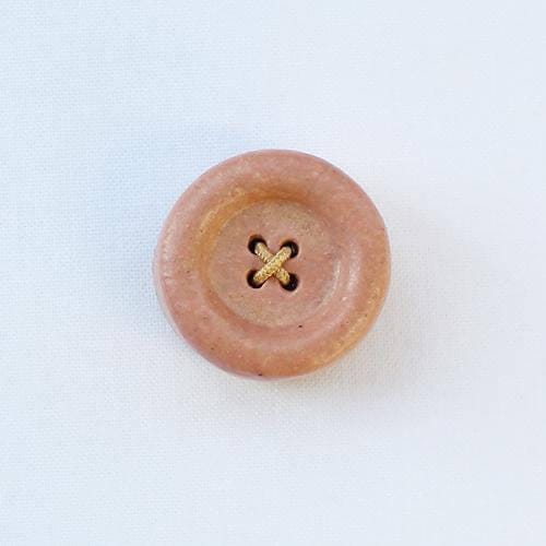 a wooden button with a cross on it