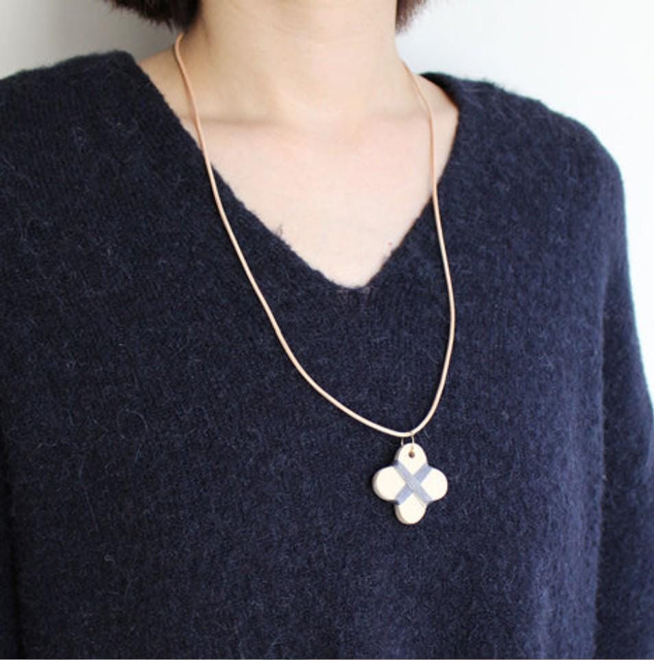 a woman wearing a necklace with a cross on it