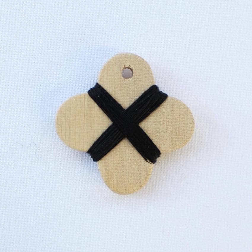 a wooden button with a cross on it