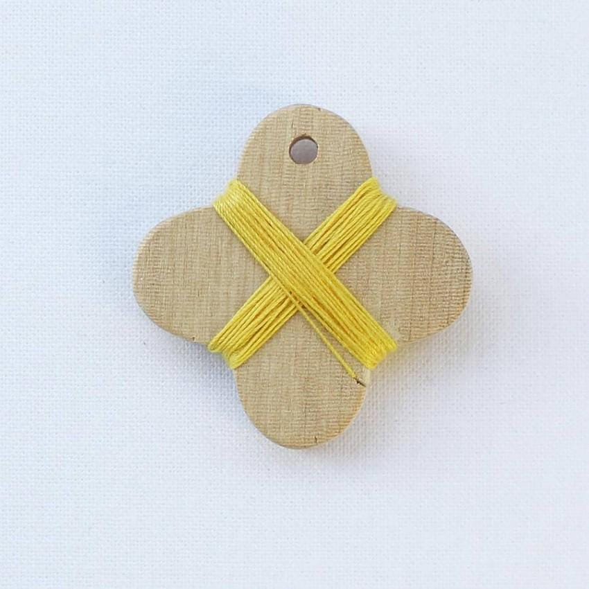 a piece of wood with a yellow string tied to it