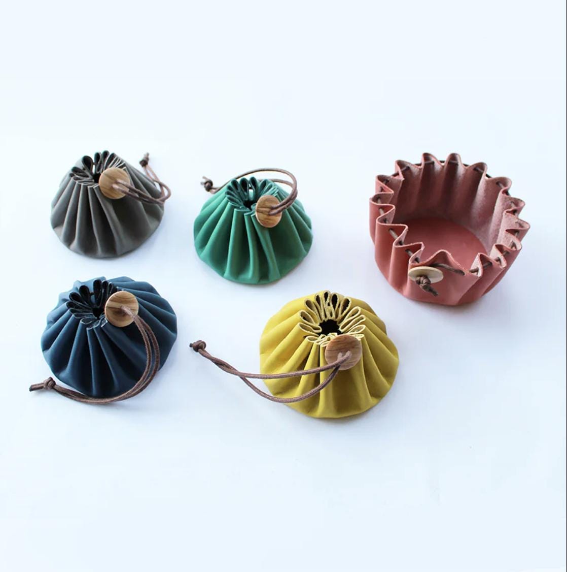 a group of four purses sitting on top of a white table