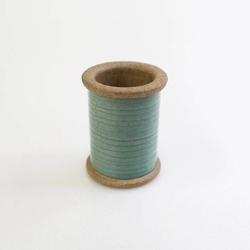 a spool of thread sitting on top of a white table