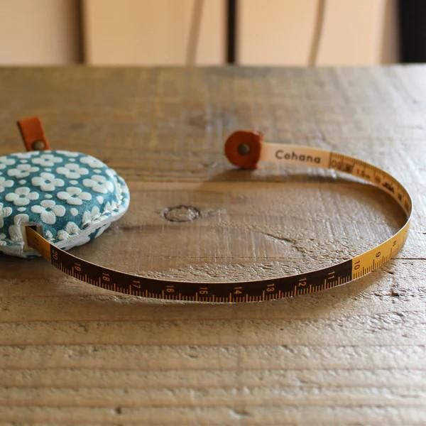a measuring tape and a pillow on a wooden table