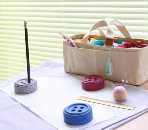 a sewing kit sits on a table next to a bag