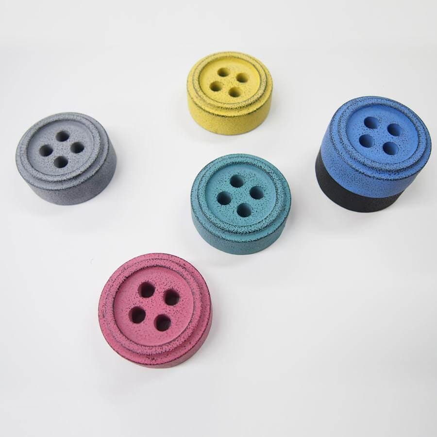 a group of four buttons sitting on top of a white table