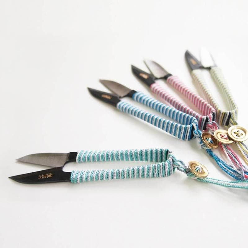 a set of four multicolored knives on a white surface