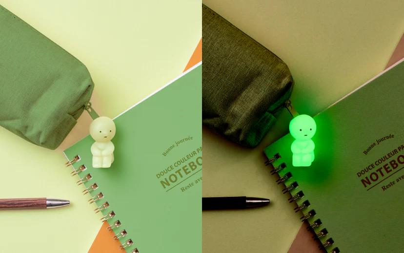 a notebook with a green light on top of it