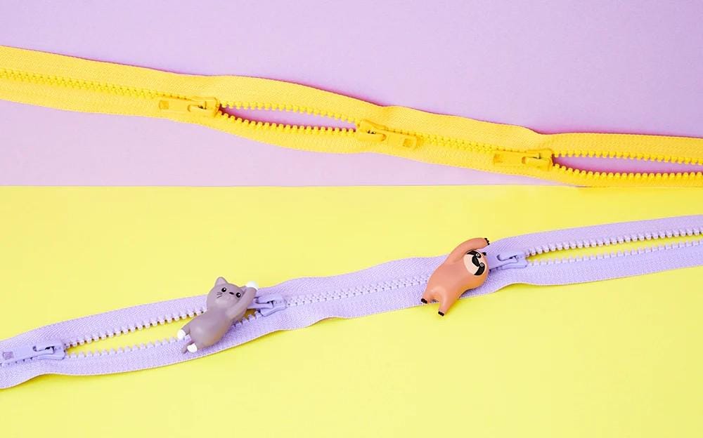 a pair of yellow and purple zippers on a yellow and purple background