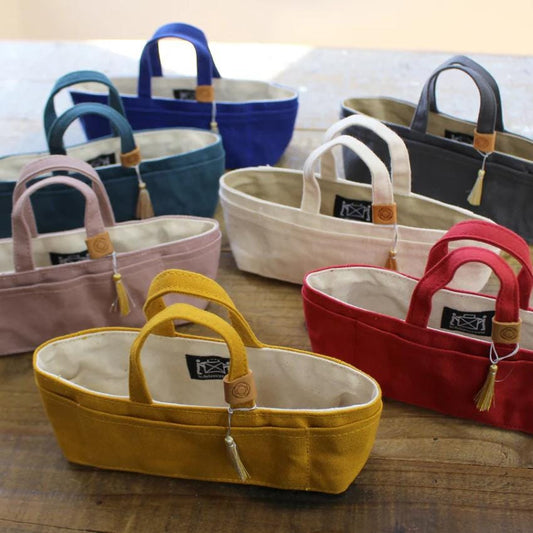 A collection of colorful handbags and tote bags arranged on a wooden surface.