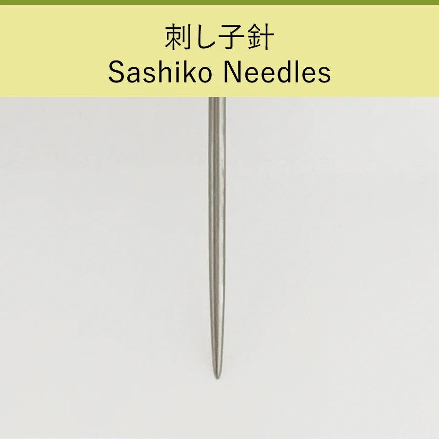 A close-up view of a silver-colored sewing needle against a plain white background.