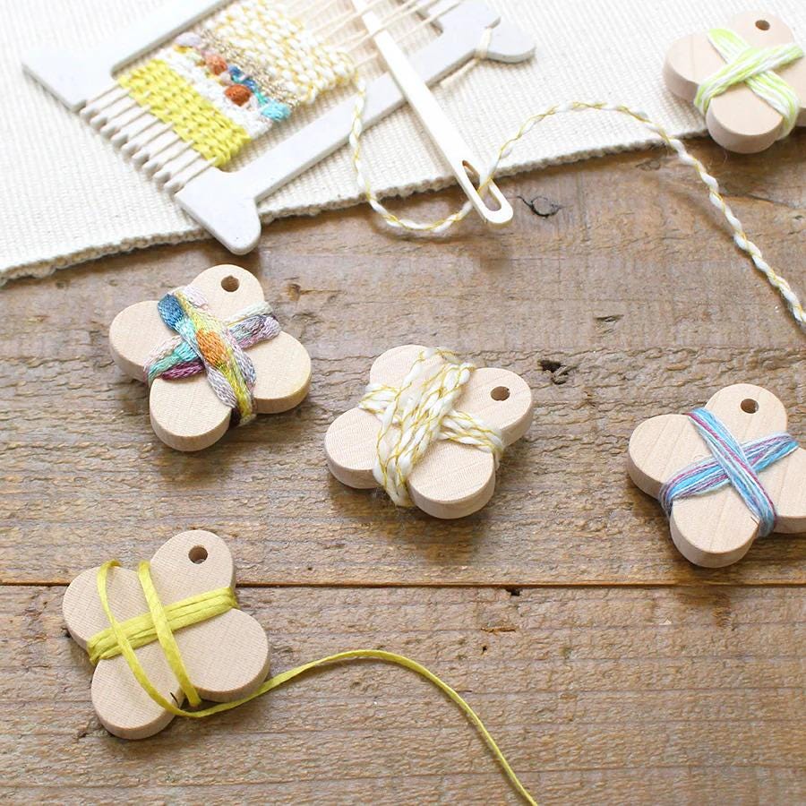 a collection of wooden beads and a loom on a wooden surface, suggesting an activity related to weaving or crafting.
