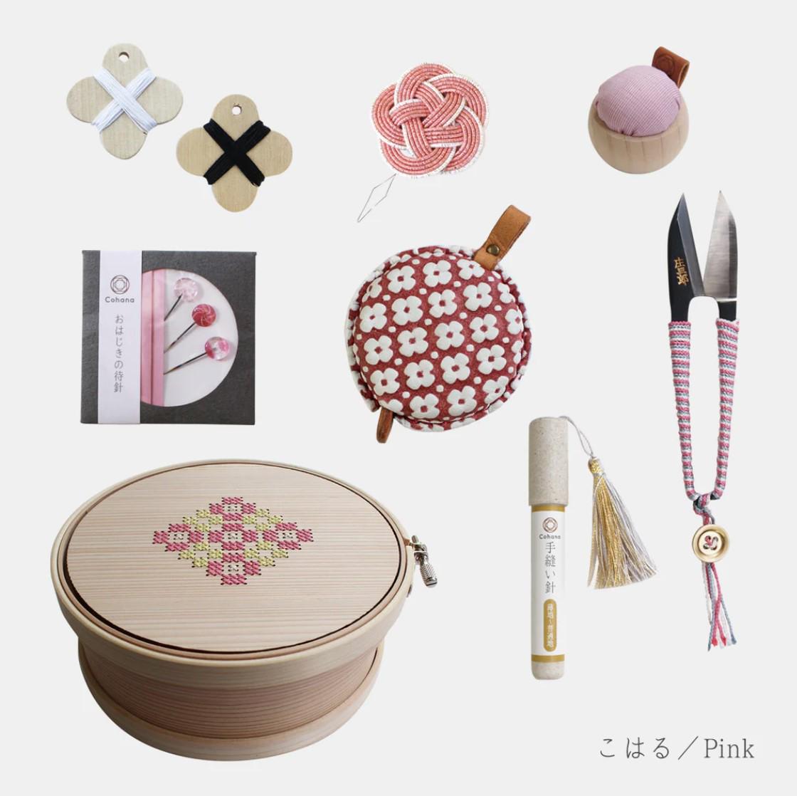 various sewing and crafting supplies, including a wooden box with a floral design, a pair of scissors, a needle, a spool of thread, a tassel, and a small ball of thread.