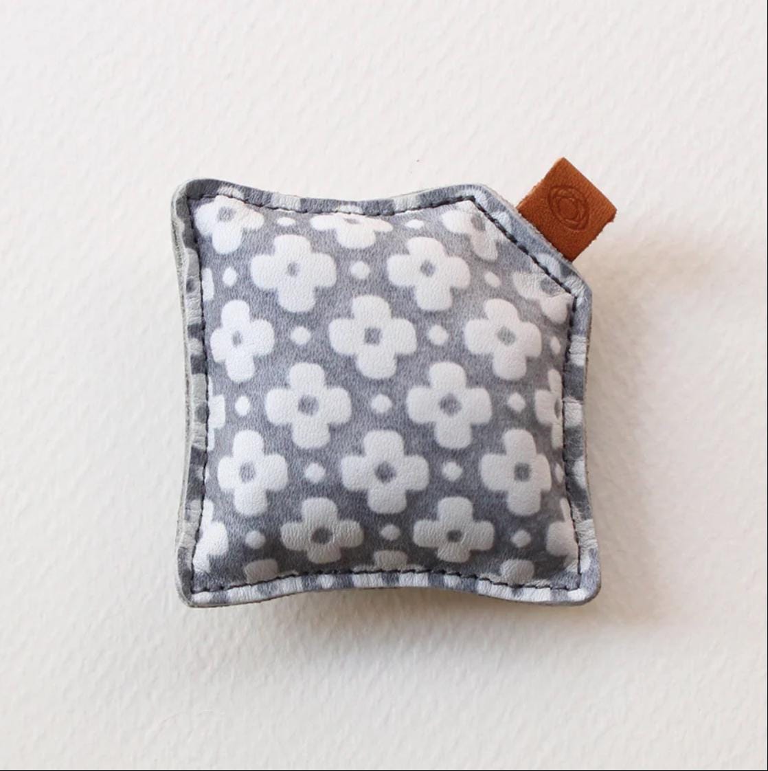 A gray and white patterned fabric with a small brown tag attached to it.