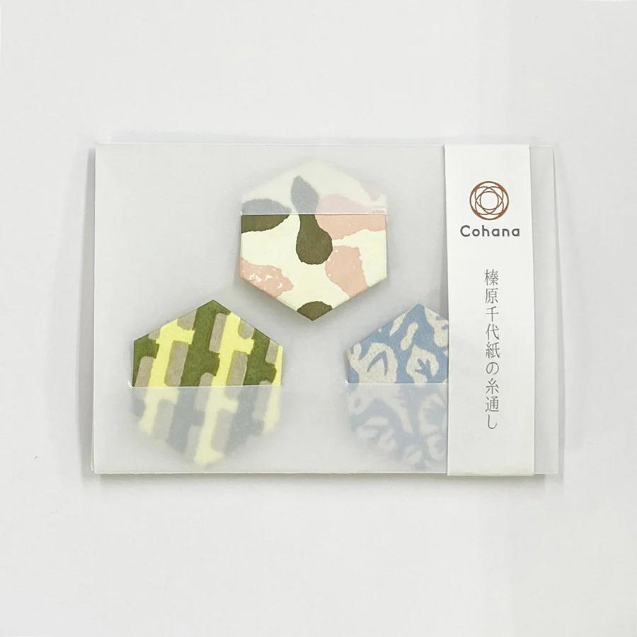 a set of three hexagonal paper designs, each with a unique pattern, displayed in a clear plastic sleeve.