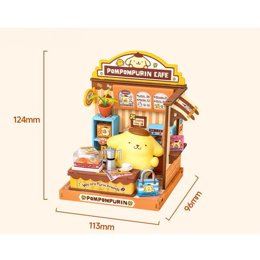 A miniature model of a Pompurin Cafe, featuring a yellow pom-pom character sitting at a counter with various items such as a coffee machine, a cake, and a handbag.