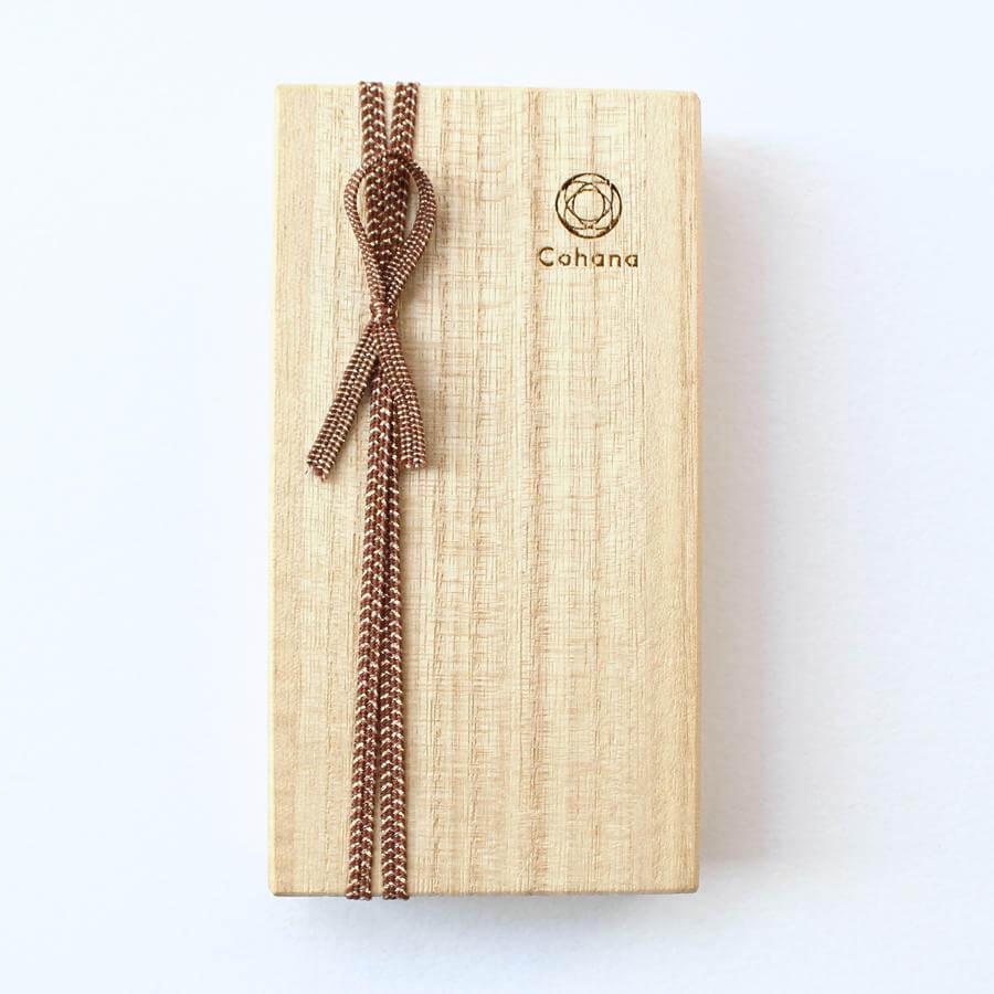 a wooden box with a decorative brown ribbon tied around it.